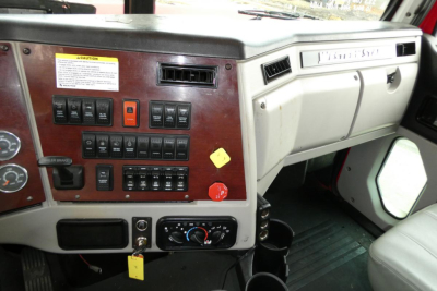 Truck cab dashboard with wood paneling showing switches, gauges, and climate controls in a 2019 Western Star 5700XE.