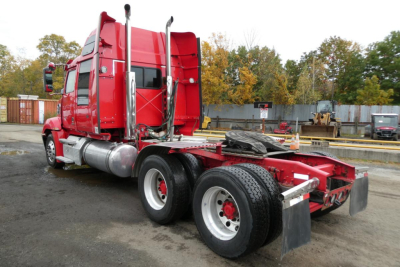 Red 2019 Western Star 5700XE tractor truck with sleeper and dual rear axles, fuel tanks, and tall exhaust stacks.
