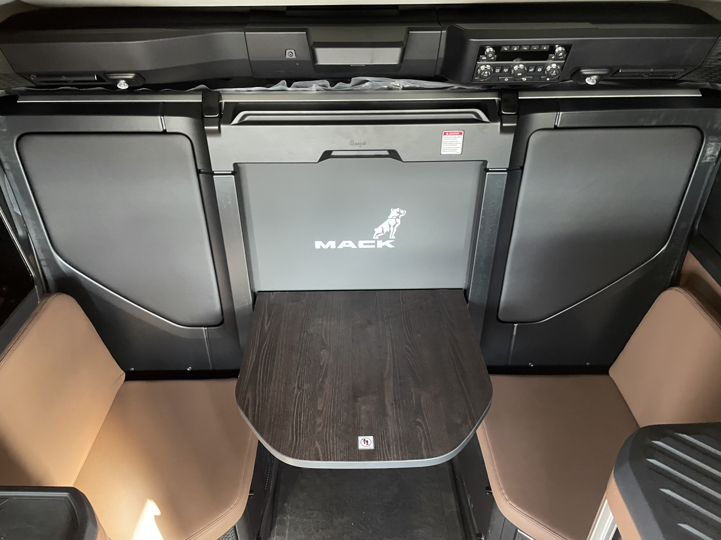 Mack PR64T76H cab interior showing center table with cup-rail and overhead dash area.