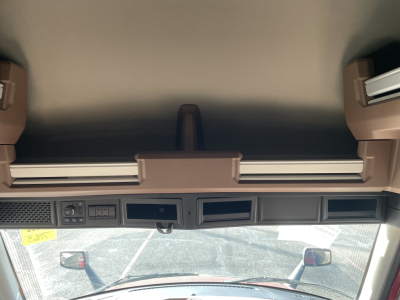 Dashboard area of a truck cab showing overhead storage handles, electrical panel, and windshield with mirrors; no legible branding or model text visible.