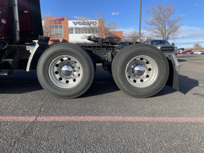Front-left and rear-left wheels of a Mack chassis showing dual rear axles and chrome hubcaps.