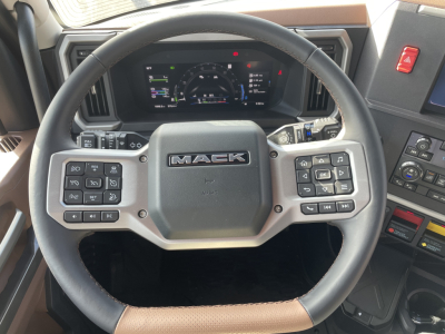 Mack PR64T76H truck interior steering wheel and dashboard showing brand badge and control buttons.