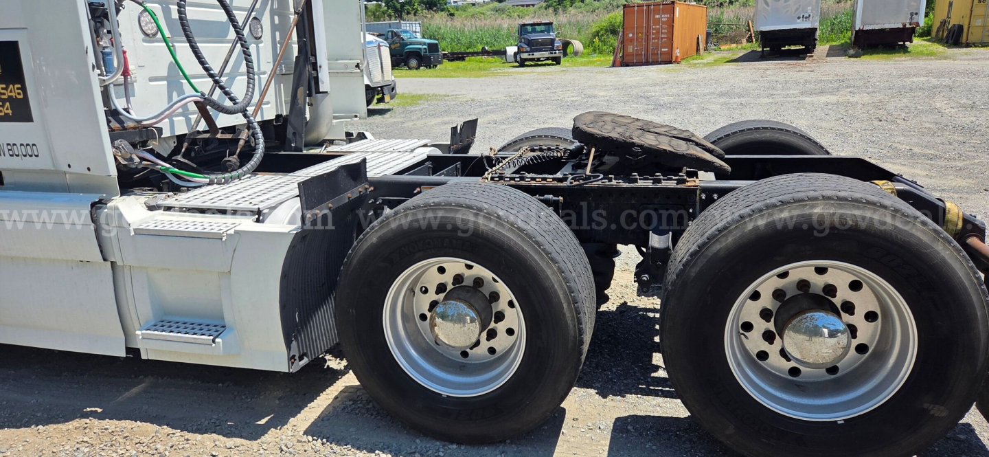 Volvo VNL tractor front wheel area showing dual rear axles and chrome hub caps.