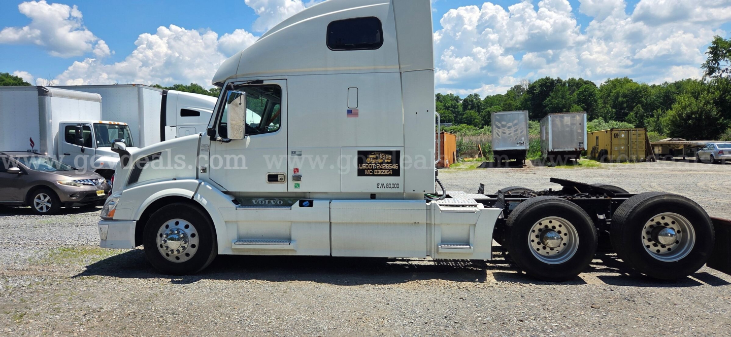 Volvo VNL tractor side view showing cab, fuel tanks, and rear axles with wheels