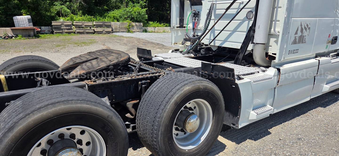 Volvo truck tractor side view showing rear dual wheels and chassis with fuel tanks and steps.