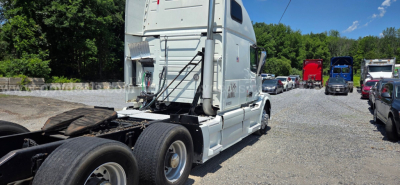 Volvo VNL truck cab rear quarter and chassis in a used truck lot with other trucks in background