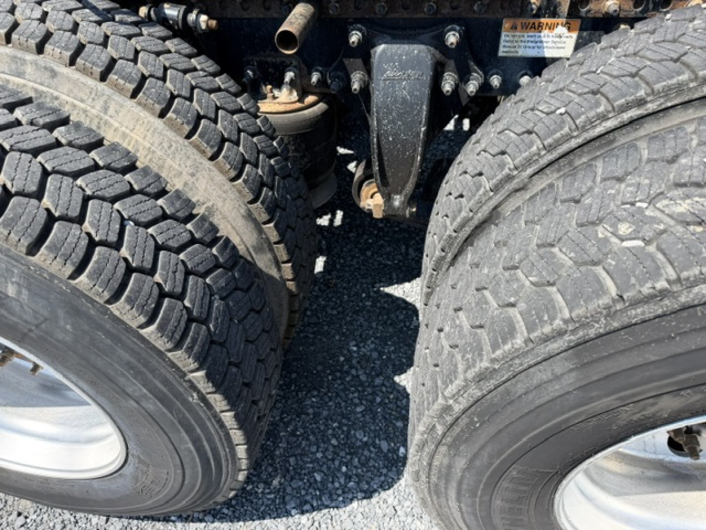Dual rear truck wheels and drivetrain area of a 2017 Freightliner Cascadia CA125DC showing rear axle assembly and suspension components.