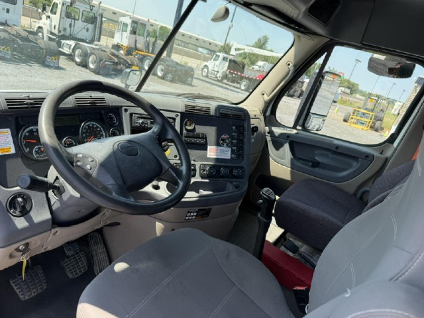 Cab interior of a 2017 Freightliner Cascadia CA125DC with steering wheel, dashboard, and driver seat visible.