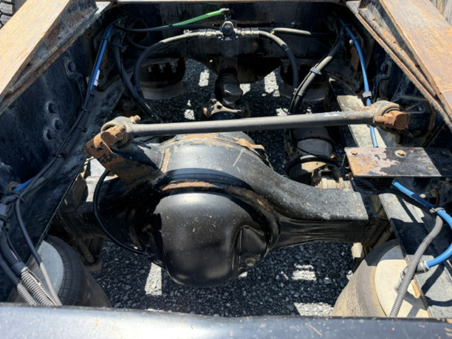 Rear view of Freightliner Cascadia CA125DC drivetrain and suspension showing differential housing and drive shaft,”