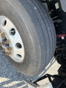 Front left wheel and tire view of a 2017 Freightliner Cascadia CA125DC with visible wheel, tire treads, and suspension components.