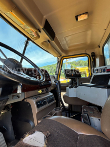 Interior cabin view of a 2006 Mack CV713 dump truck showing steering wheel, dashboard, and operator controls.
