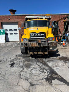 Mack CV713 dump truck front view in yellow with large grille and 'MACK' logo, stock number 30360, in-service used truck.