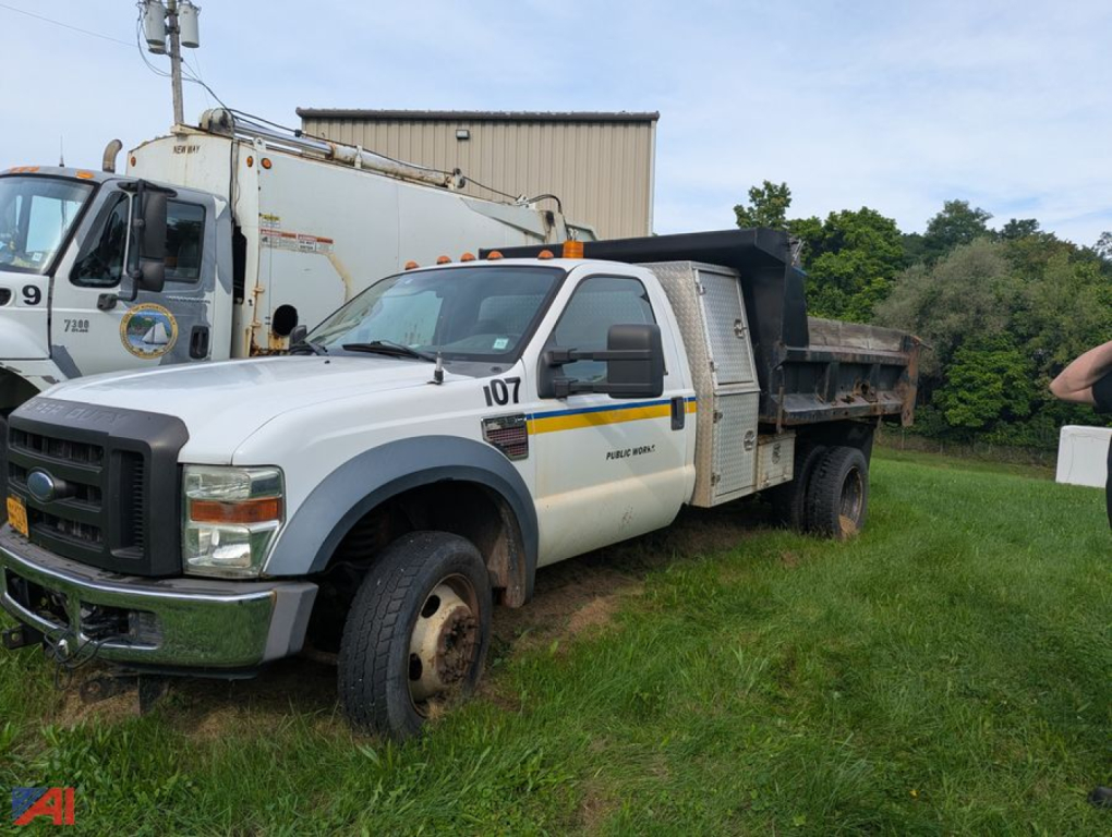 Ford F-550 Super Duty dump truck in-field side view showing dump bed and front bumper.