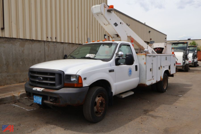 Ford F-450 Super Duty bucket truck with utility body and elevated bucket arm, white cab, in-service condition.