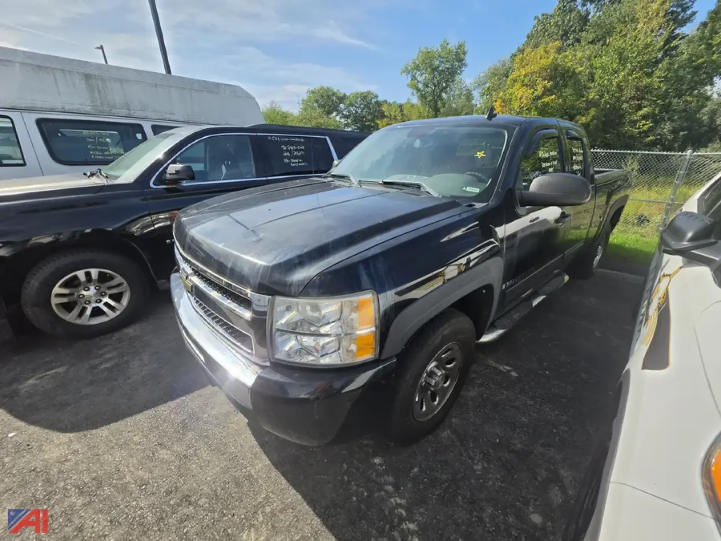 Chevrolet Silverado pickup truck in a lot, front-right view with headlights, grille, and chrome bumper visible.