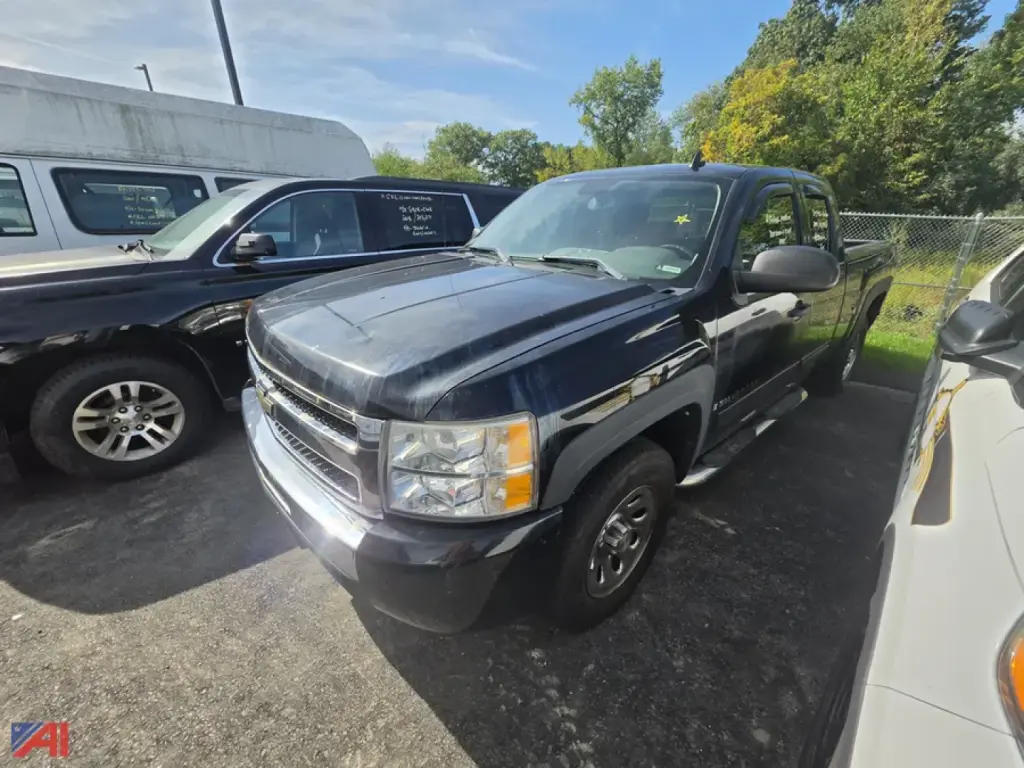 Chevrolet Silverado pickup truck in a lot, front-right view with headlights, grille, and chrome bumper visible.