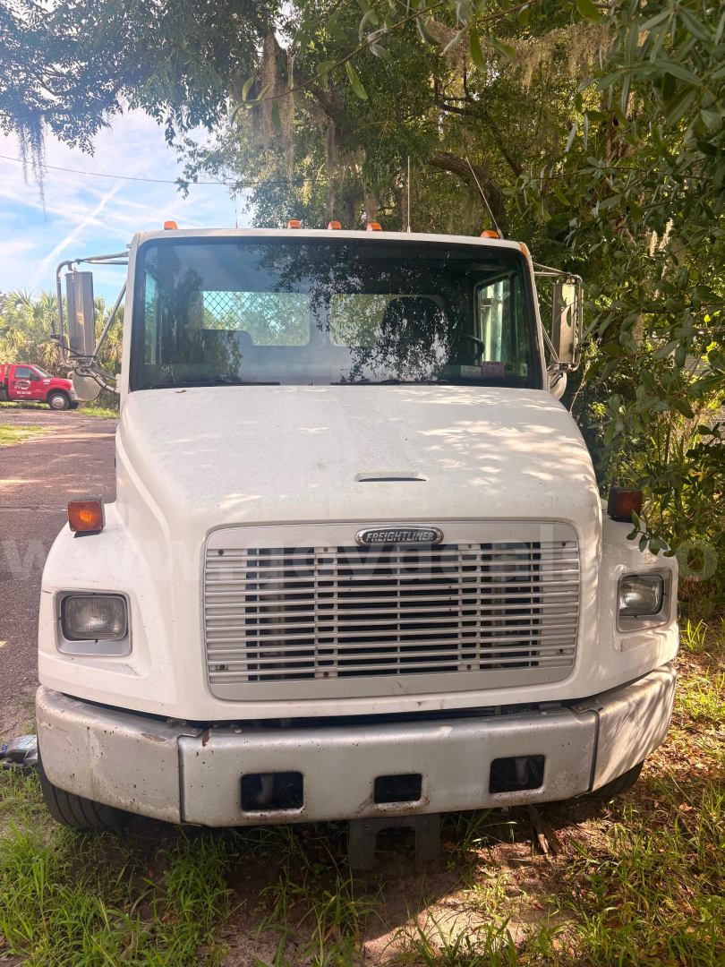 Front view of a white 2003 Freightliner FL80 tow truck showing large grille, bumper, headlights, and windshield with side mirrors.