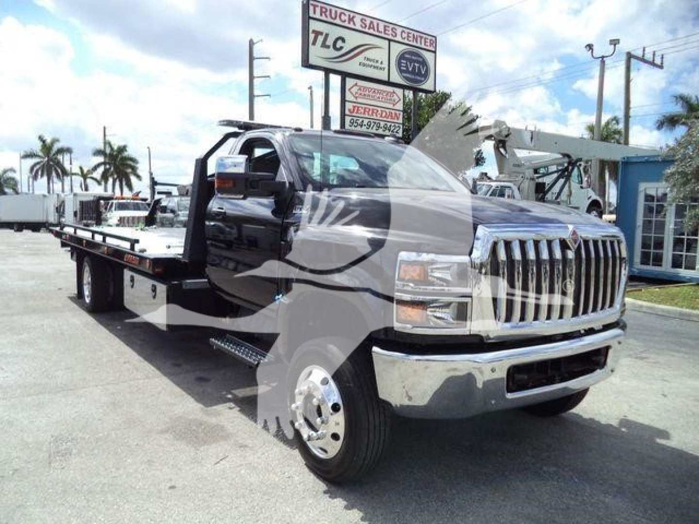 Truck flatbed tow truck in a dealership lot showing a 2023 International CV with long flatbed and chrome grille; visible VIN 1HTKTSWK6PH441635 and stock number J41635