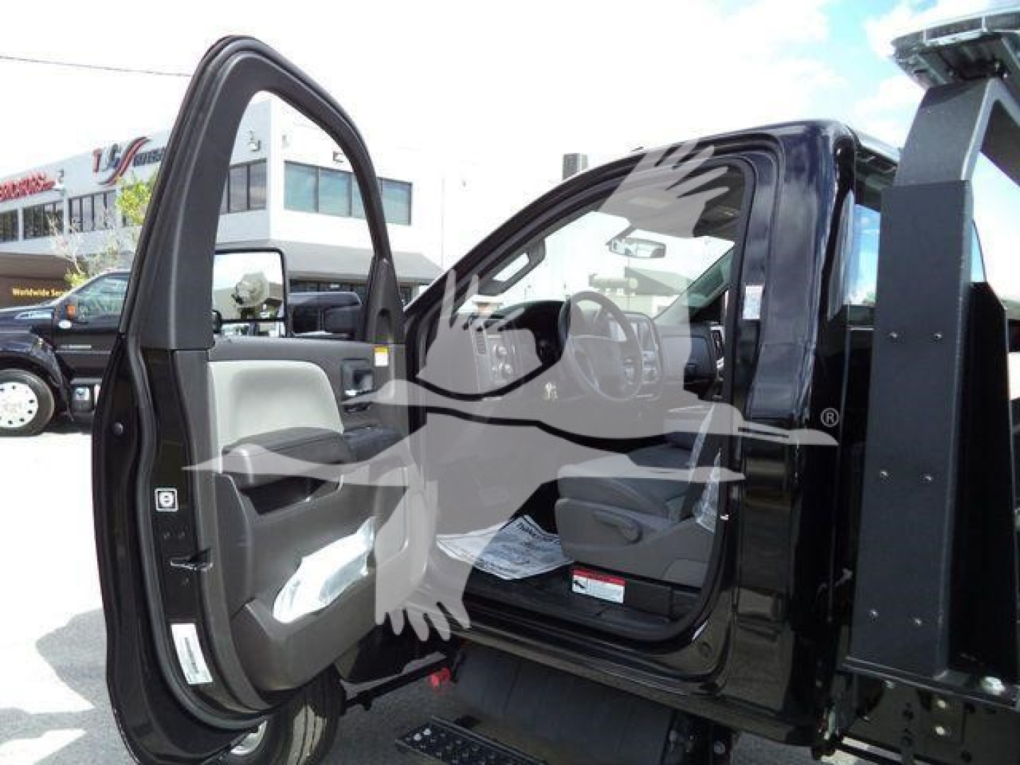 Truck cab with open driver door showing interior and part of rollback body, International CV likely, VIN in listing.