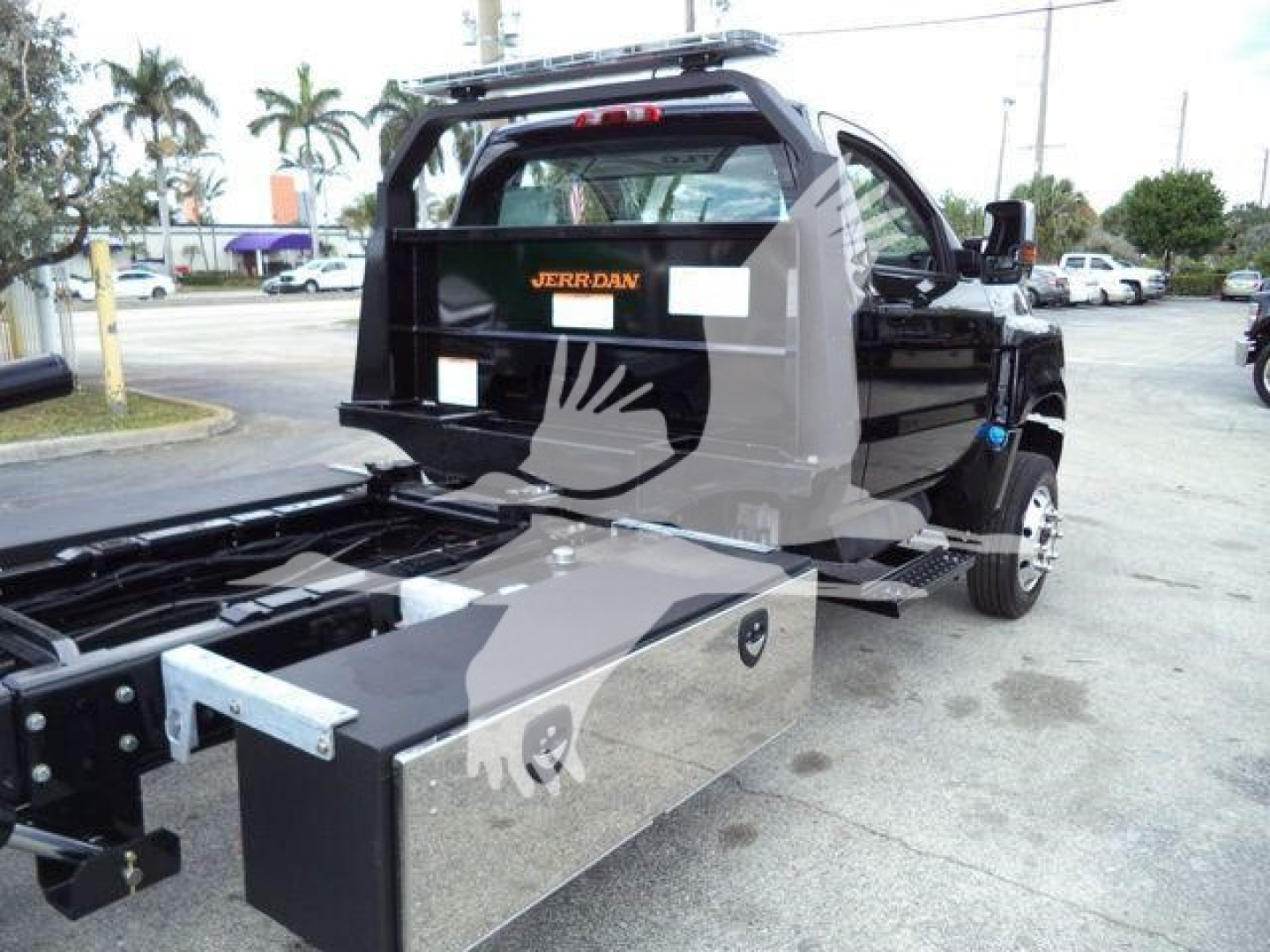 Truck bed area with toolbox and rear cab view of 2023 International CV rollback truck. Visible text: 'JERRDAN' on rear barrier.