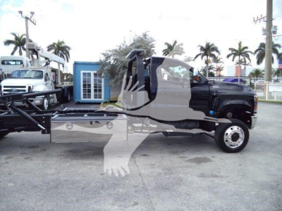 Truck cab and rollback wrecker chassis visible with extended flatbed and wheel; VIN plate and stock number not legible; palm trees in background.