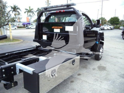 Truck bed area with toolbox and rear cab view of 2023 International CV rollback truck. Visible text: 'JERRDAN' on rear barrier.