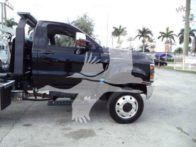 Truck side view showing a black 2023 International CV rollback w/ front wheel and cab; VIN 1HTKTSWK6PH441635 visible on listing; parked in lot.