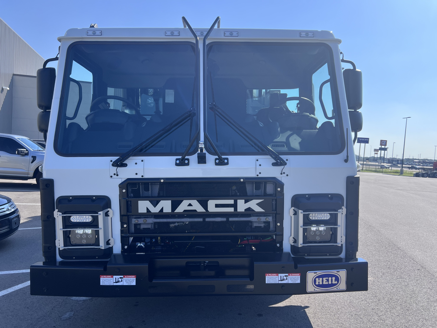 Mack LR64 cab front showing large grille with MACK logo, dual windshield wipers, square headlights, and front bumper with HEIL badge.