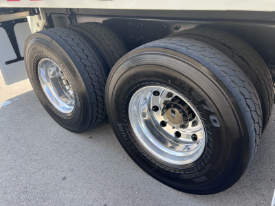 Mack LR64 wheel area showing two rear dual tires with polished aluminum rims and tread detail.