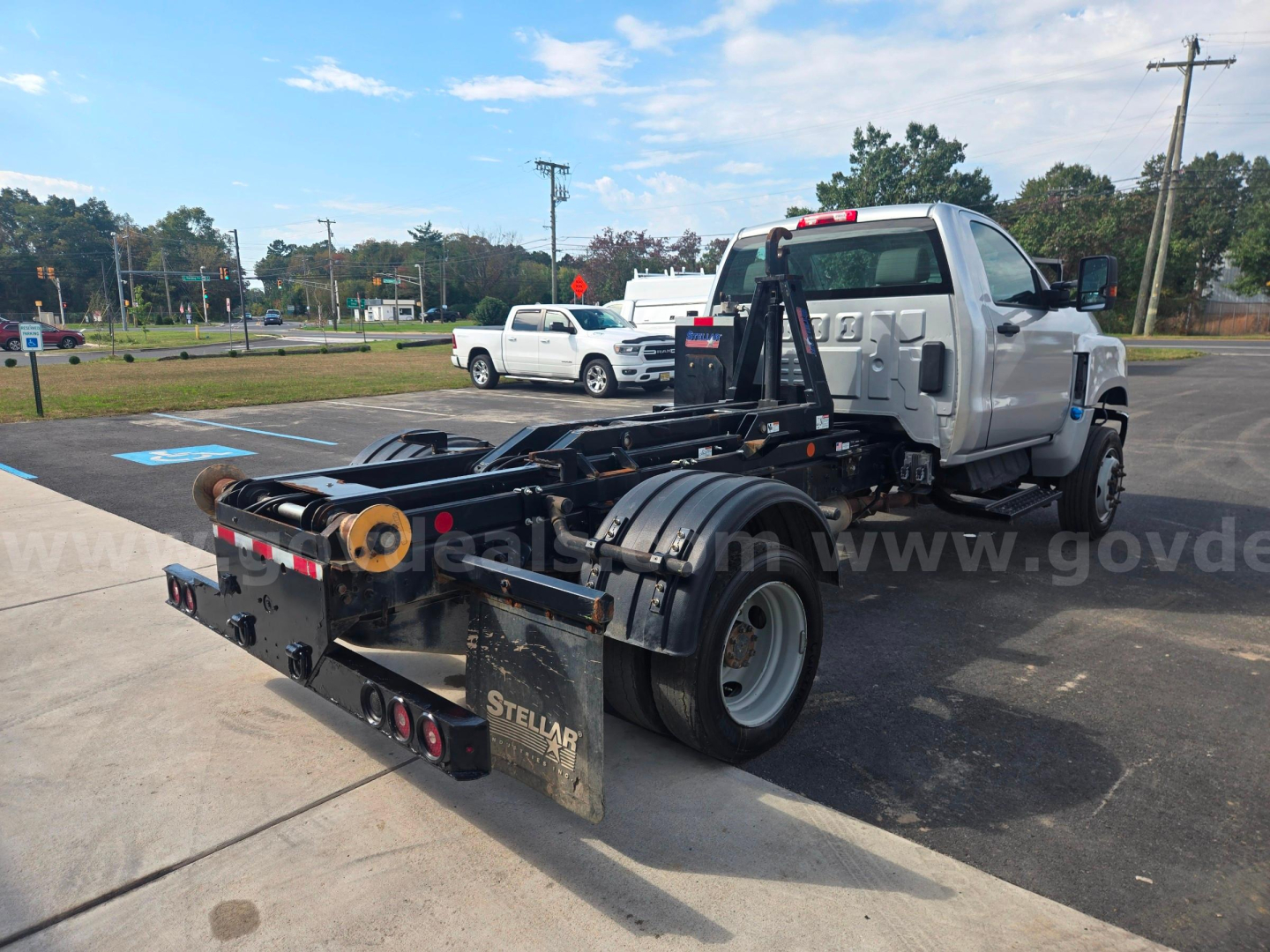 Truck chassis with tiltbed in-service showing Stellar wheel well and hydraulic components.