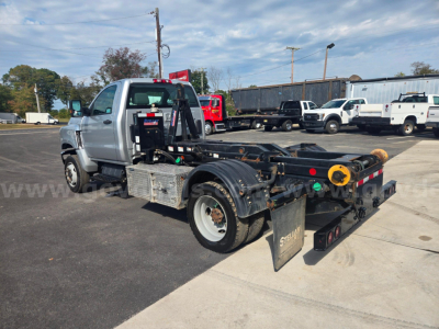 Dump truck chassis with a car carrier or hook-lift style bed, 2023 Chevrolet 6500, stock 29174-99, in a dealership lot.