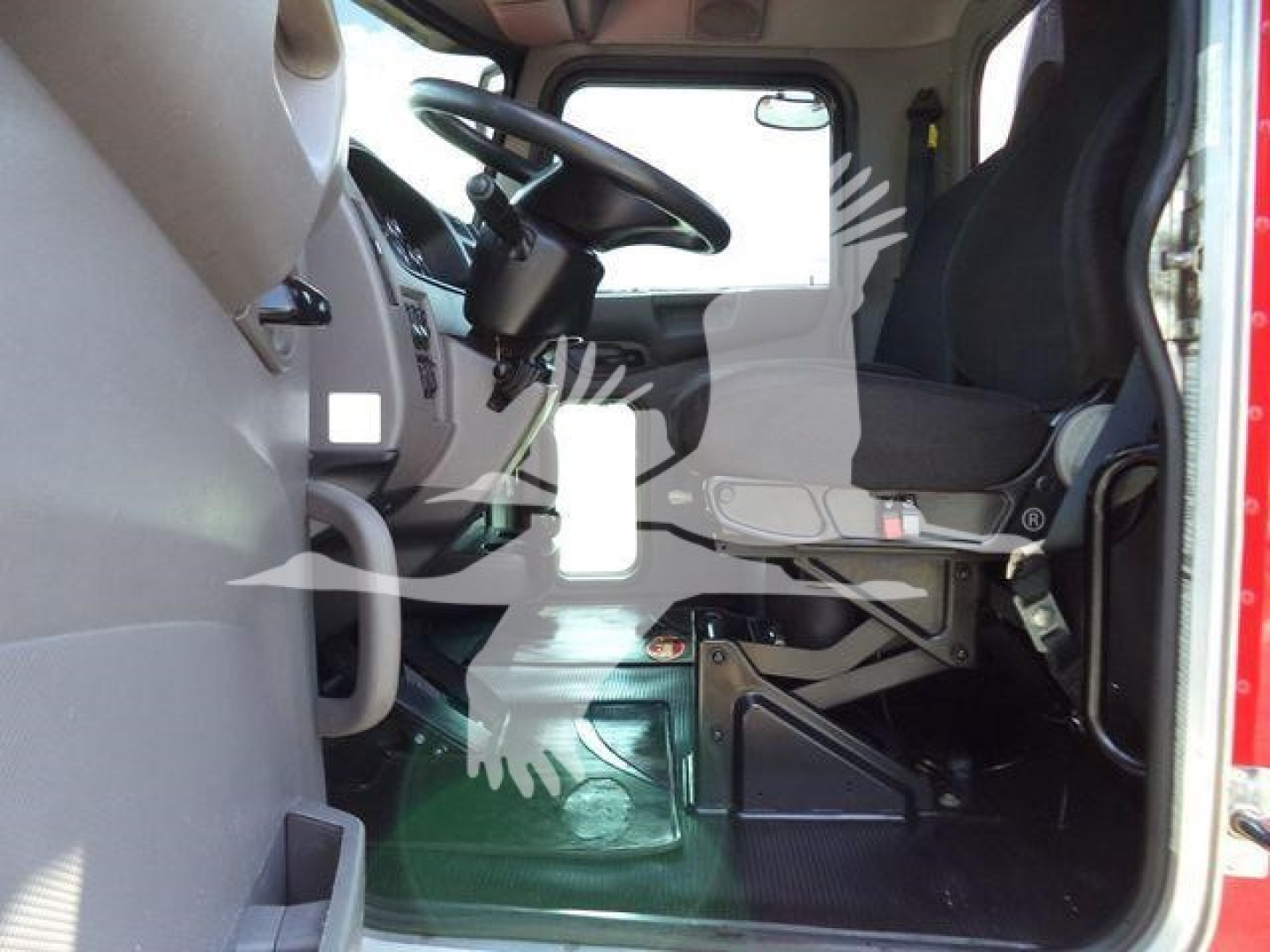 Peterbilt truck cab interior showing steering wheel, driver seat, and dashboard area with light and entry step