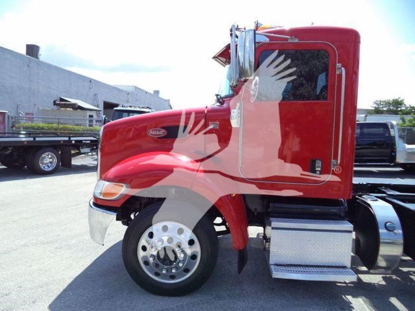 Peterbilt 337 cab in red paint, side view showing front wheel, chrome bumper, and fuel tank.