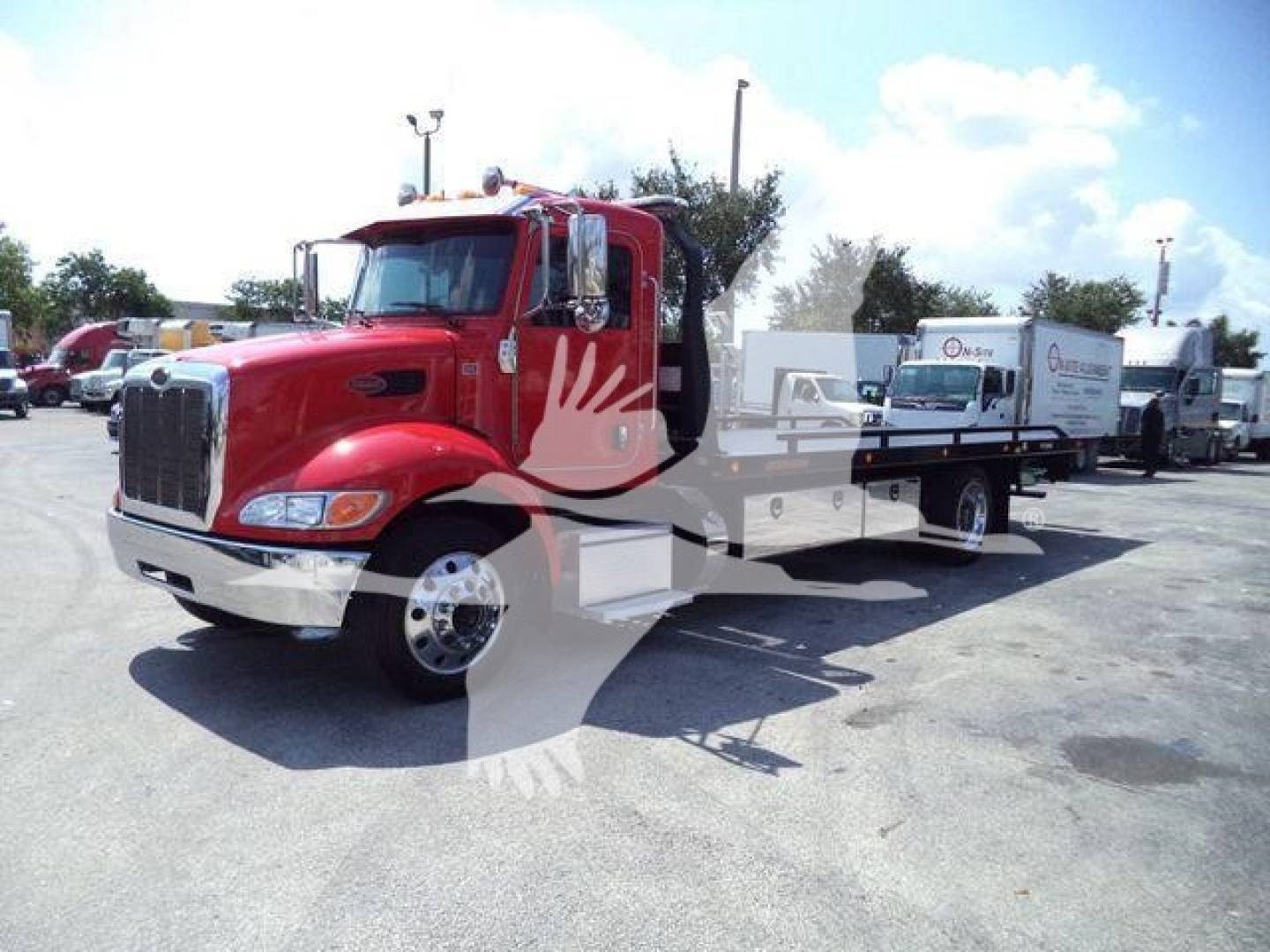 Peterbilt 337 rollback truck in red with flatbed, side view showing front grille and mirrors.