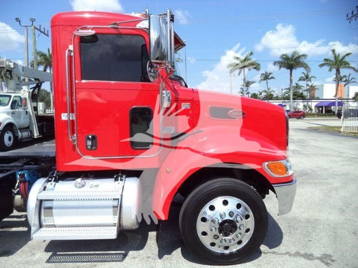 Peterbilt 337 rollback truck side view showing red cab, chrome exhaust stack, steps, and wheel with polished hubcap.