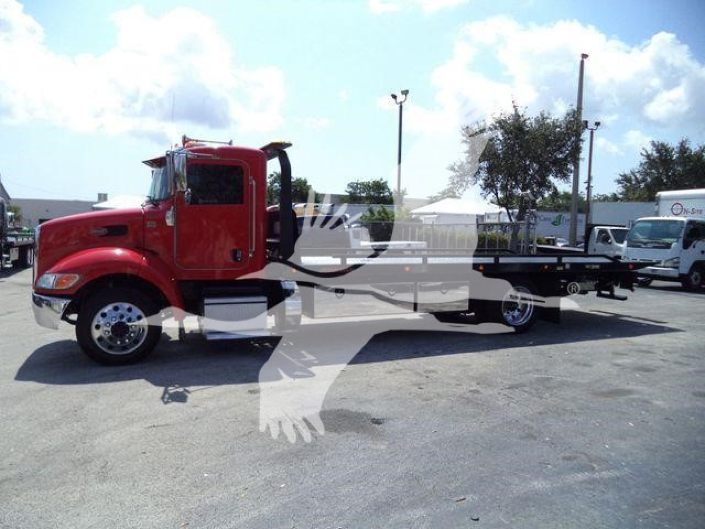 Peterbilt 337 rollback truck side view showing red cab and flatbed.