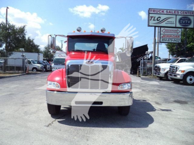Peterbilt 337 roll-back truck front view in red color with large grille and chrome bumper.