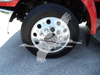 Peterbilt 337 front wheel with polished steel rim and black tire; partial red fender and undercarriage visible.