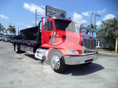 Peterbilt 337 rollback tow truck in red showing front and side view with chrome grille and flatbed