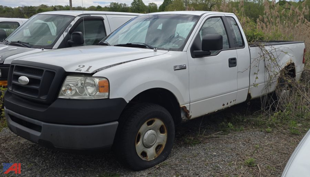 Ford F-150 XL pickup truck profile showing front grille and side view with rust around wheel wells.