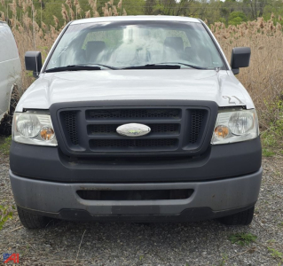Front view of a white 2008 Ford F-150 XL pickup truck with black grille, bumper, and side mirrors on a gravel lot.