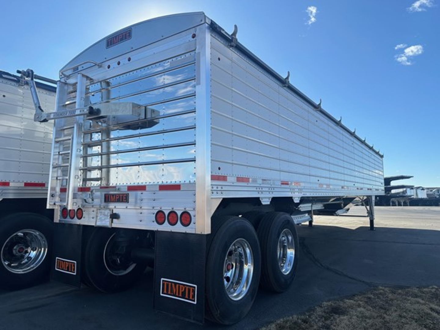 Timpte Super Hopper trailer with 66 inch sides, tandem axles, aluminum panels, rear doors, and mudflaps displaying Timpte branding.