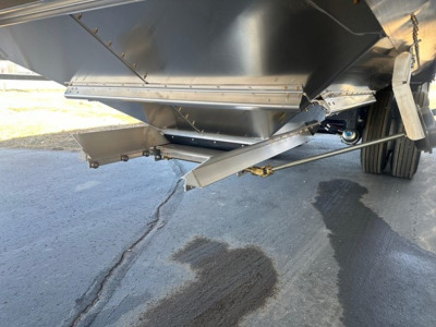 Hopper trailer underside view showingmetal chute and hydraulic components with 66" side walls.