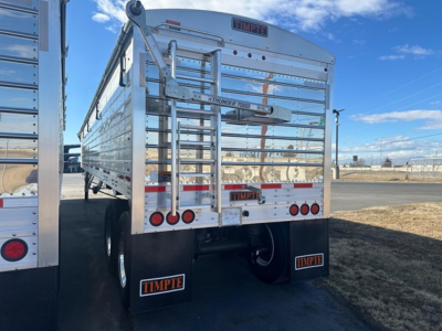 Timpte Super Hopper trailer rear view showing 66" sides, chrome gates, vertical bars, rear lights, mud flaps with Timpte logos, and a ladder on the left.