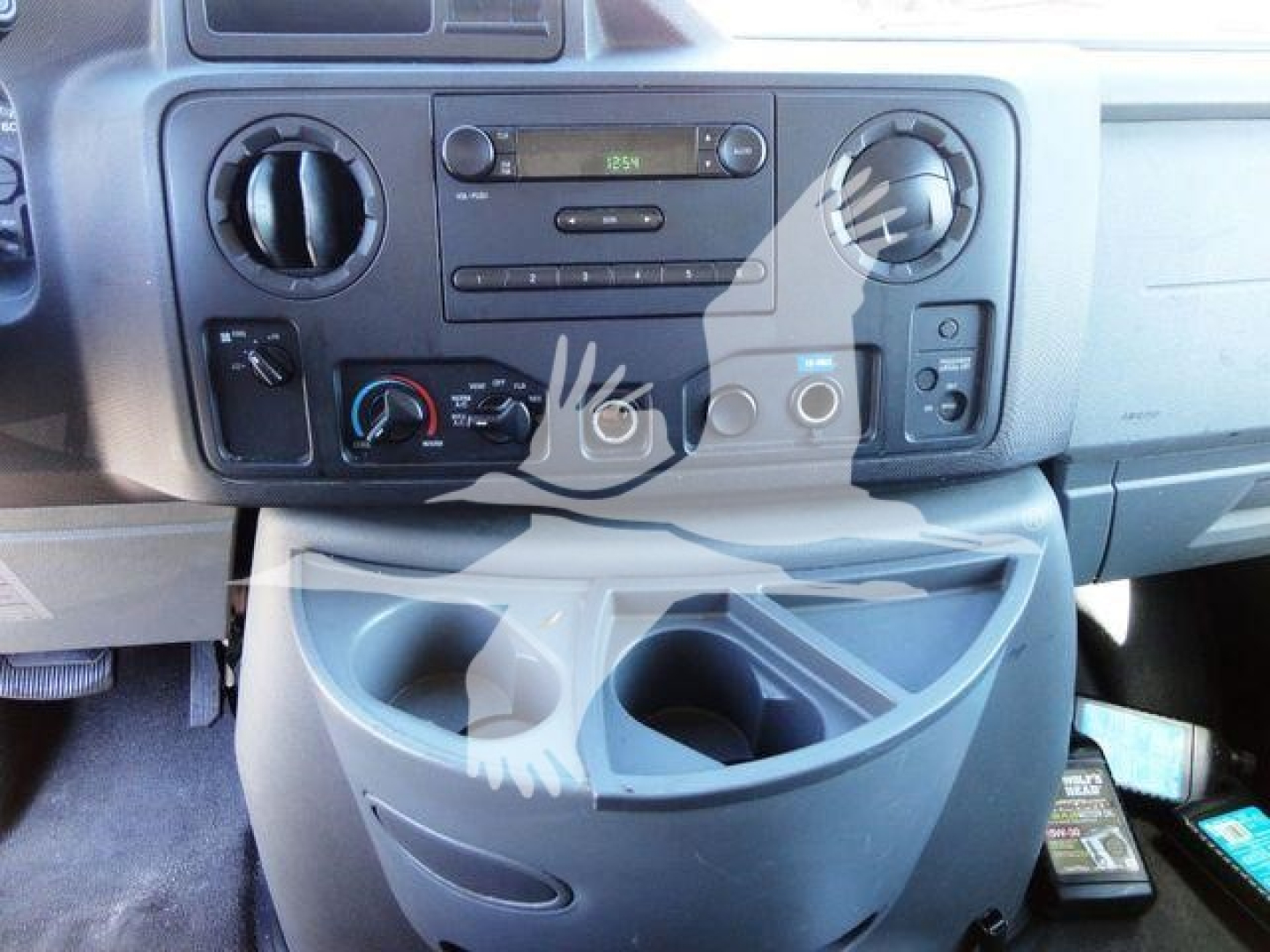 Ford E-Series cab interior showing dashboard radio, climate controls, and center console storage cup holder area in a Ford E450 flatbed truck.