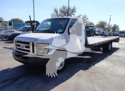 Ford E450 flatbed tow truck in-service showing long flatbed and front grille with Ford emblem.