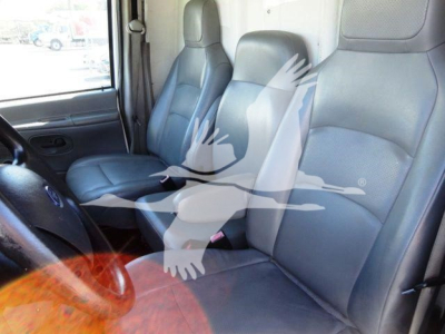 Ford E-Series cargo van interior showing driver and passenger seats with vinyl upholstery.