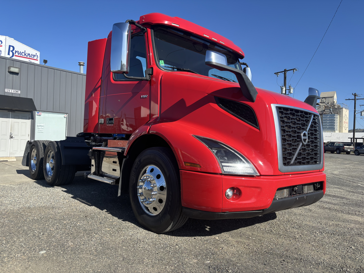 Volvo VNR64T300 truck in red, front three-quarter view showing grille, headlights, chrome mirrors, and dual rear axles.