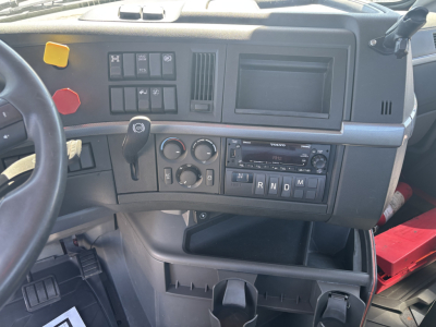 Volvo VNR64T300 truck cabin dashboard showing steering wheel, gear shift, control switches, and digital display panel with R N D M indicators.