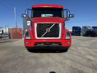 Volvo VNR64T300 truck front view showing Volvo grille and emblem, red cab, headlights, and bumper.